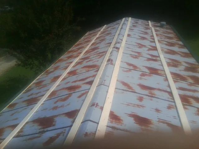 Rusted metal roof panels with new wood purlins before replacement — Storm Damage Roof Repair in Medway by Roofing Brothers
