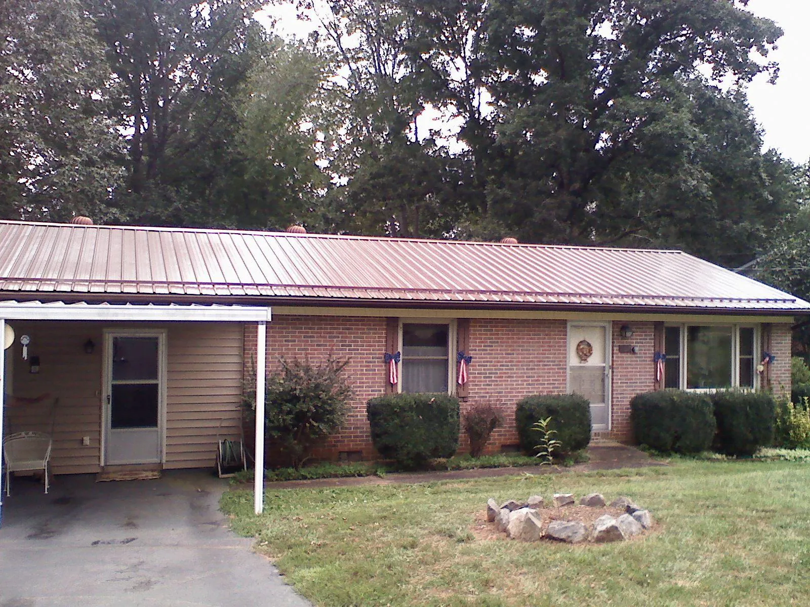 Bronze metal roof and carport on a brick ranch home — Roof Repair work by our crew in Medway